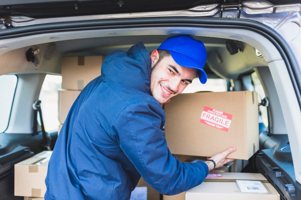 cheerful-man-with-boxes-delivery_23-2147767547