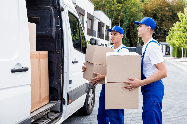 two-removal-company-workers-unloading-boxes-from-minibus-into-new-home_179755-15534