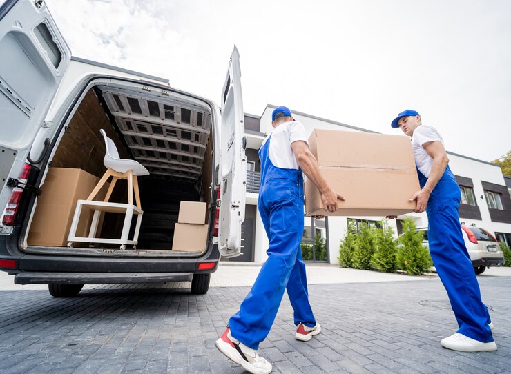 two-removal-company-workers-unloading-boxes-furniture-from-minibus_179755-13990
